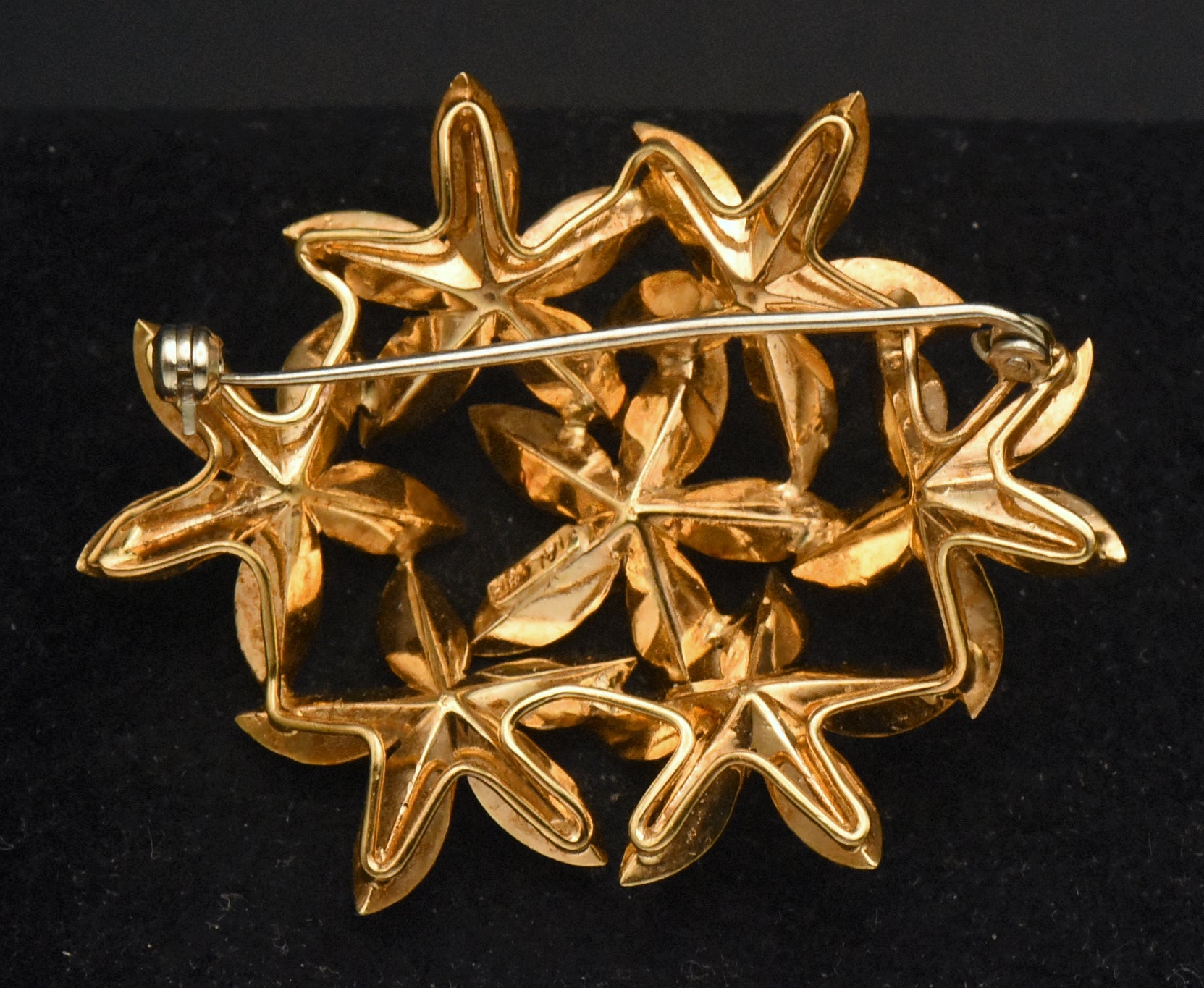 Stunning vintage antique handcrafted 18k gold brooch consisting of seven flowers with florentine finish, each set with a round cut sapphire.