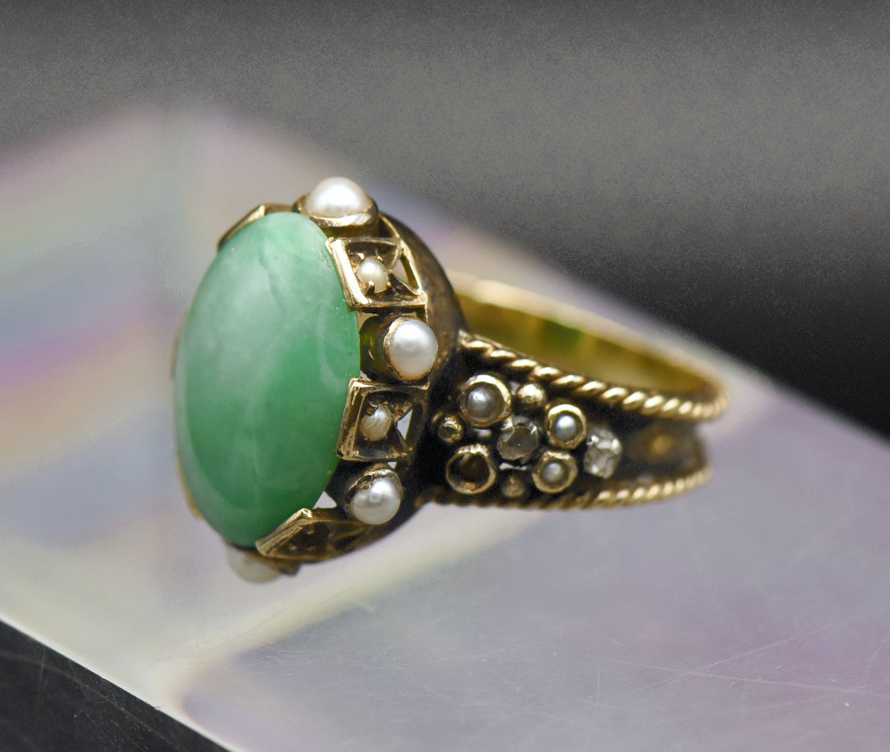 Gorgeous handmade vintage 18k gold ring, set with a lovely oval cabochon of jade, accented with bezel set pearls of various sizes, as well as rose cut diamonds.