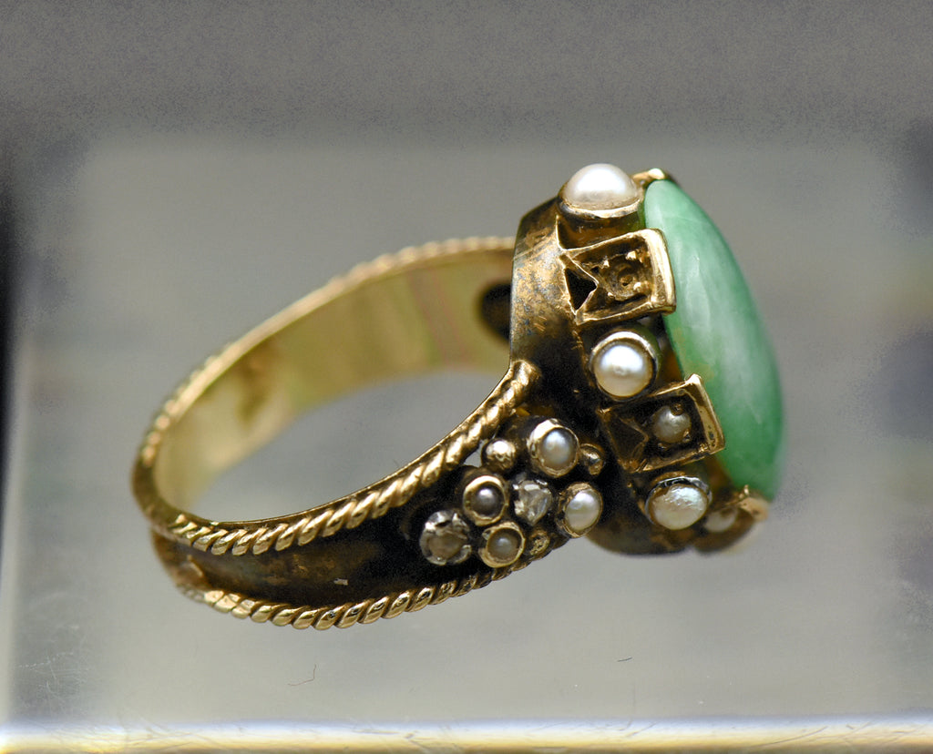 Gorgeous handmade vintage 18k gold ring, set with a lovely oval cabochon of jade, accented with bezel set pearls of various sizes, as well as rose cut diamonds.